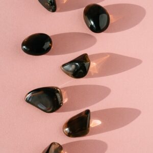 Top view of composition of small healing gemstones minerals for relaxation and meditation on pink background