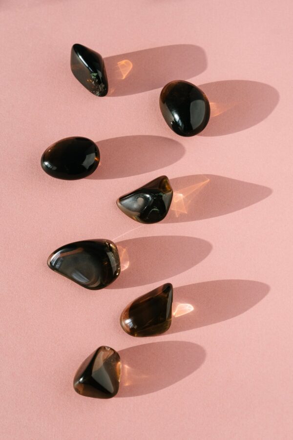 Top view of composition of small healing gemstones minerals for relaxation and meditation on pink background